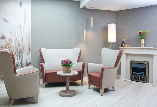 Salon avec canapé, fauteuils, table basse et cheminée