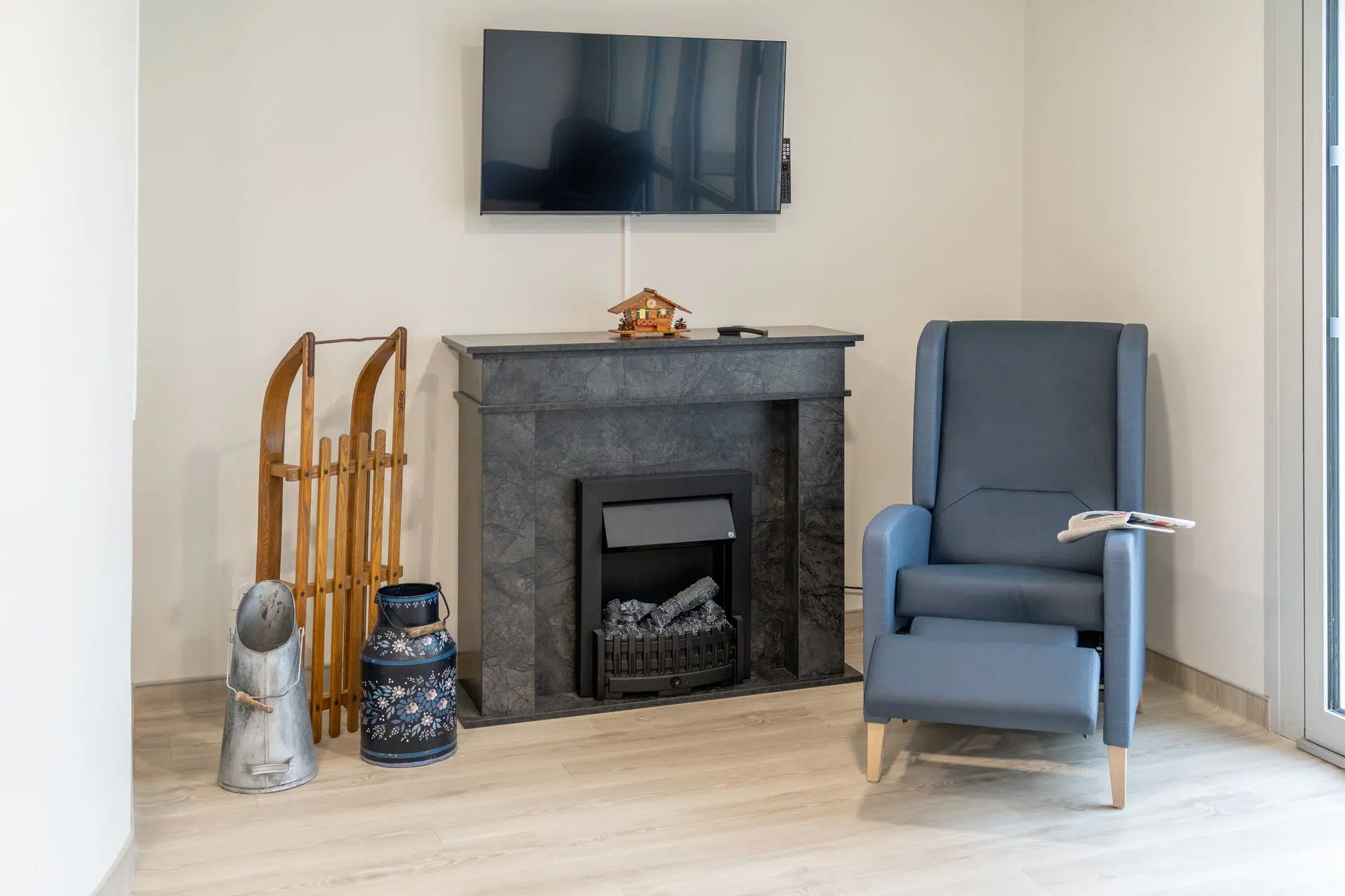 Fauteuil inclinable et cheminée électrique dans un salon d'EHPAD