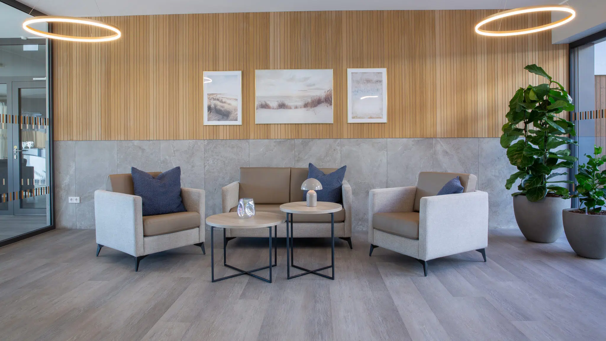 Salon lumineux d’EHPAD aménagé avec fauteuils, canapés et tables basses CARELINE